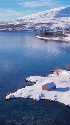 Experience the breathtaking beauty of Tromso, Norway during winter. Discover the serene beaches, icy waters, and snow-capped mountains and fishing village.