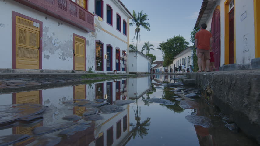 Tourists walk on the street of the colonial town of Paraty filled with water, Brazil