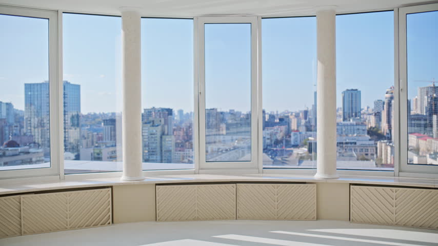 Man woman arriving luxury apartment with luggage, pointing panoramic window cityscape. Real estate buyers inspecting empty flat, unrecognizable back view, excited happy couple relocation moving.