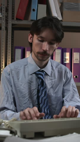 Office worker typing in a dim archive room