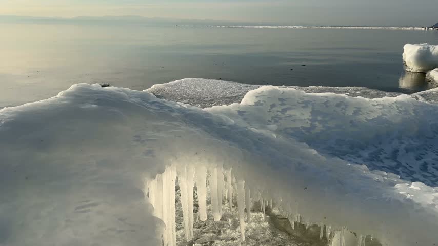 Video of Baikal Lake in December. Waves wash up ice mounds known as Sokui onto beach, shores become covered with whimsical ice crusts and icicles. Unusual waterscape. Changing of seasons