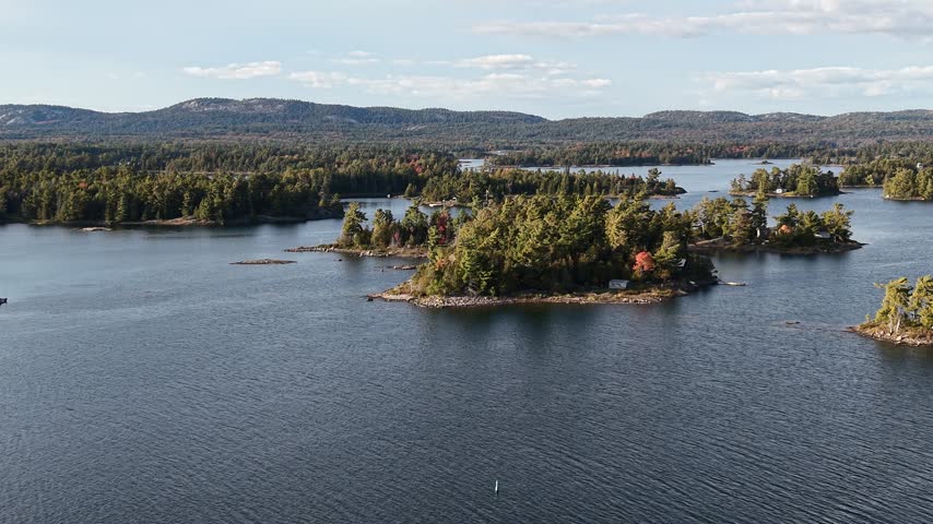 Aerial View of Serene Rocky Island with Cabin and Dock on Calm Lake - Northern Ontario