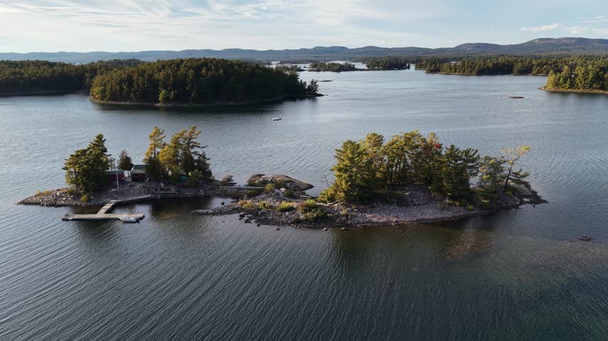 Aerial View of Serene Rocky Island with Cabin and Dock on Calm Lake - Northern Ontario