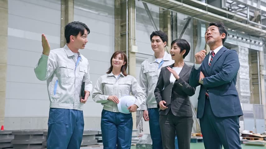 A male worker giving a visitor a tour of the factory.