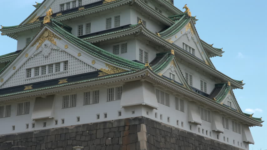 Osaka Castle Tenshukaku close-up, historic samurai castle keep with golden ornaments and green tiled roofs in Osaka, Japan