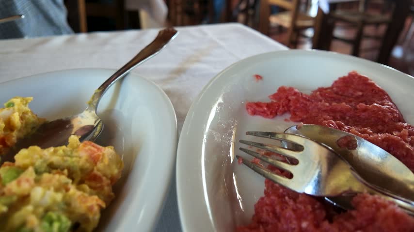 Beef tartare, Russian salad, and cured salami on a restaurant table in Piedmont.