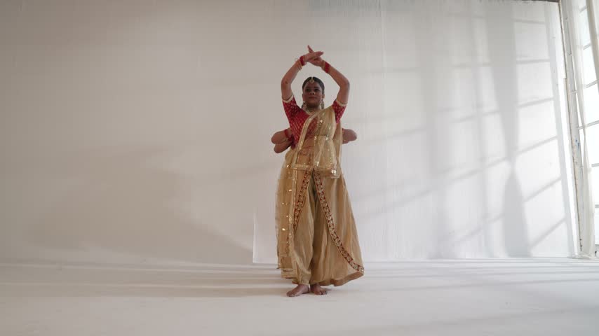 Indian classical dancers performing synchron ed movements indoors