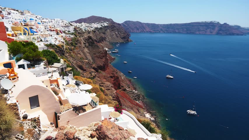 Panoramic view of Santorini island, Greece. Cycladic architecture on the caldera cliffs in Oia town. Blue sea and the blue sky at sunny day. Travel and summer vacation concept