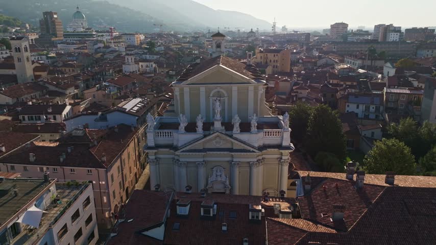 Aerial drone view of Chiesa dei Santi Nazaro e Celso in Brescia, Italy, showcasing the historic church, neoclassical architecture, rooftops, and surrounding Lombardy cityscape.