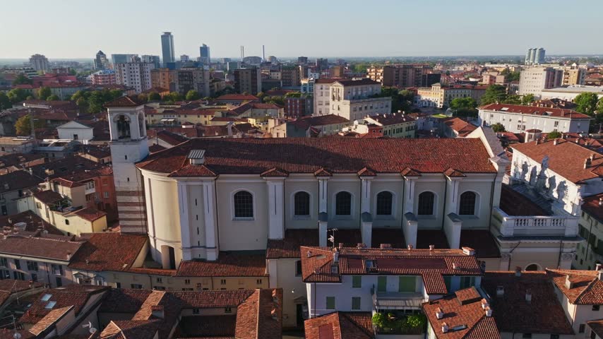 Aerial drone view of Chiesa dei Santi Nazaro e Celso in Brescia, Italy, showcasing the historic church, neoclassical architecture, rooftops, and surrounding Lombardy cityscape.