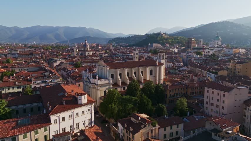 Aerial drone view of Chiesa dei Santi Nazaro e Celso in Brescia, Italy, showcasing the historic church, neoclassical architecture, rooftops, and surrounding Lombardy cityscape.