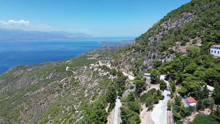 Holy Monastery of Saint Patapios, Loutraki, Corinthia, Greece - July 6th, 2026 - footage of the christian orthodox monastery situated on the slopes of Mountain Geraneia, pine trees, caves, small square and the churches during the sunny weather