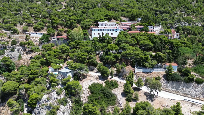 Holy Monastery of Saint Patapios, Loutraki, Corinthia, Greece - July 6th, 2026 - footage of the christian orthodox monastery situated on the slopes of Mountain Geraneia, pine trees, caves, small square and the churches during the sunny weather