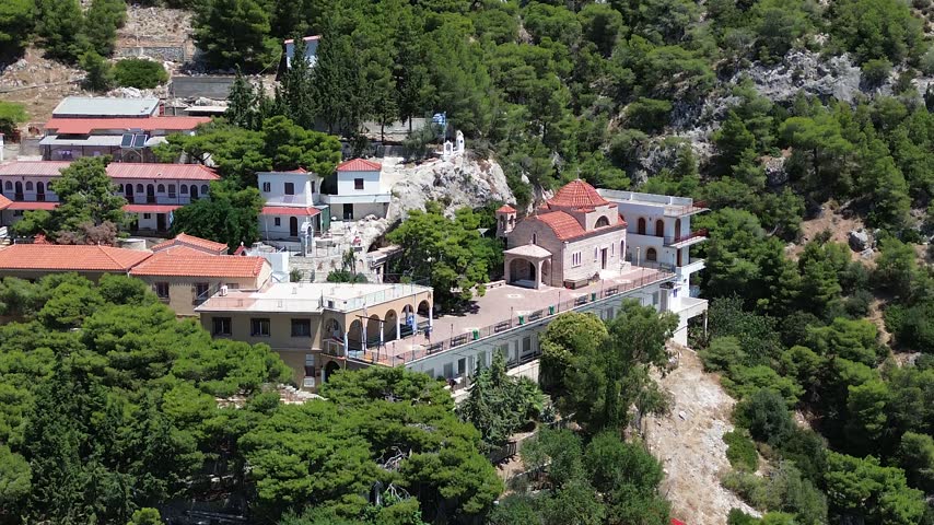 Holy Monastery of Saint Patapios, Loutraki, Corinthia, Greece - July 6th, 2026 - footage of the christian orthodox monastery situated on the slopes of Mountain Geraneia, pine trees, caves, small square and the churches during the sunny weather