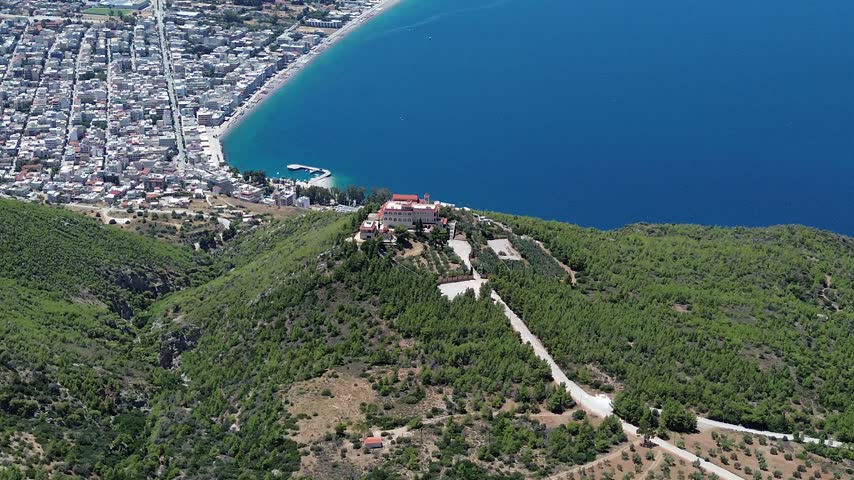 Holy Monastery of Saint Patapios, Loutraki, Corinthia, Greece - July 6th, 2026 - footage of the christian orthodox monastery situated on the slopes of Mountain Geraneia, pine trees, caves, small square and the churches during the sunny weather