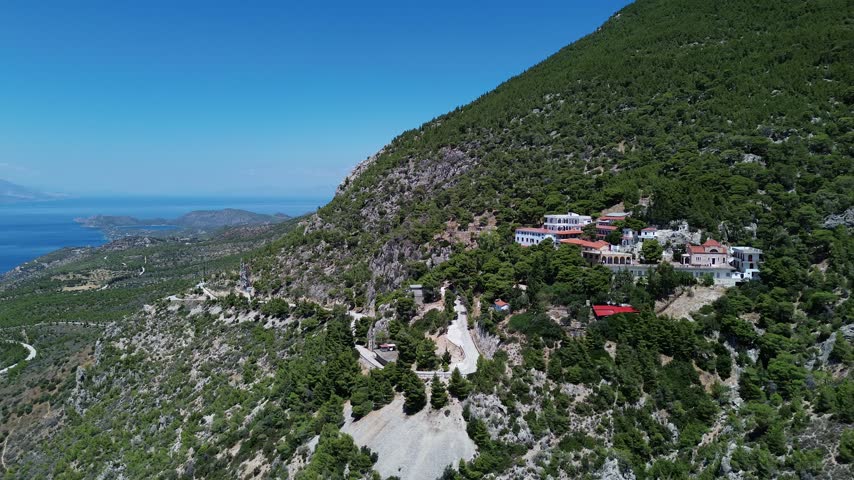 Holy Monastery of Saint Patapios, Loutraki, Corinthia, Greece - July 6th, 2026 - footage of the christian orthodox monastery situated on the slopes of Mountain Geraneia, pine trees, caves, small square and the churches during the sunny weather
