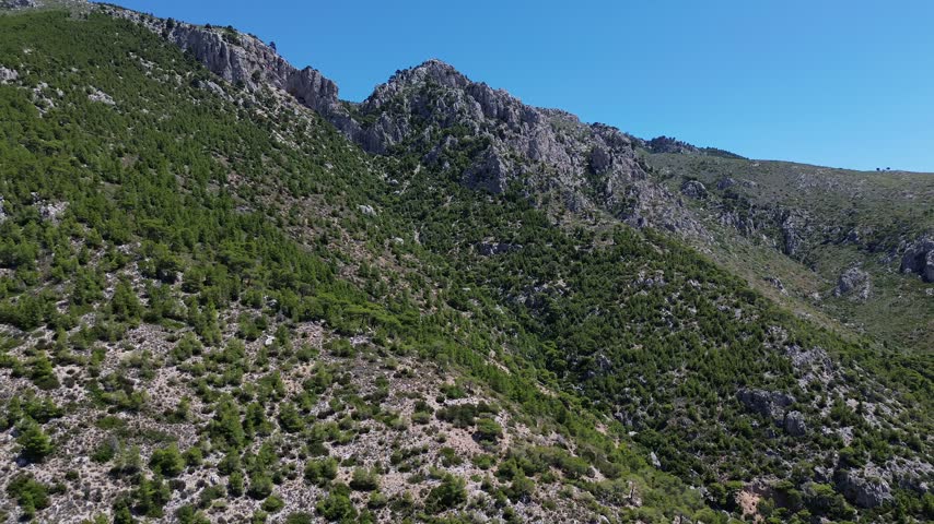 Holy Monastery of Saint Patapios, Loutraki, Corinthia, Greece - July 6th, 2026 - footage of the christian orthodox monastery situated on the slopes of Mountain Geraneia, pine trees, caves, small square and the churches during the sunny weather