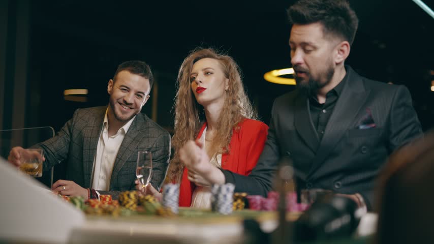 Friends celebrating a win at a casino table. Gambling night, jackpot and luxury entertainment