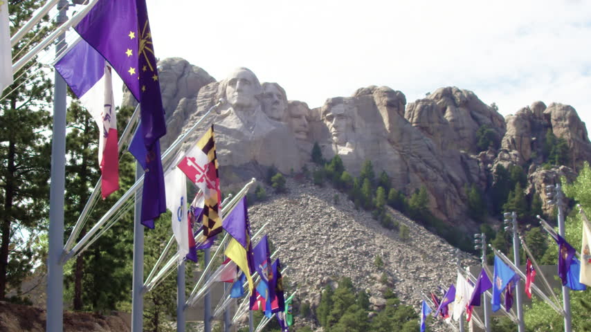 A Scenic View Of Mount Rushmore In South Dakota With State Flags.