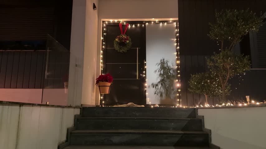 Christmas decorated front entrance with wreath and warm lights