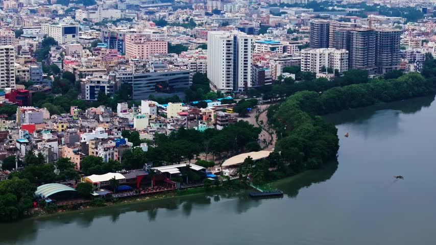 Hussain sagar lake view with Bar, restaurants, boating point, independent houses, skylines and THE PARK hotel at Necklace Road, hyderabad, telangana, india. day time, push in shot, drone shot, 4k.