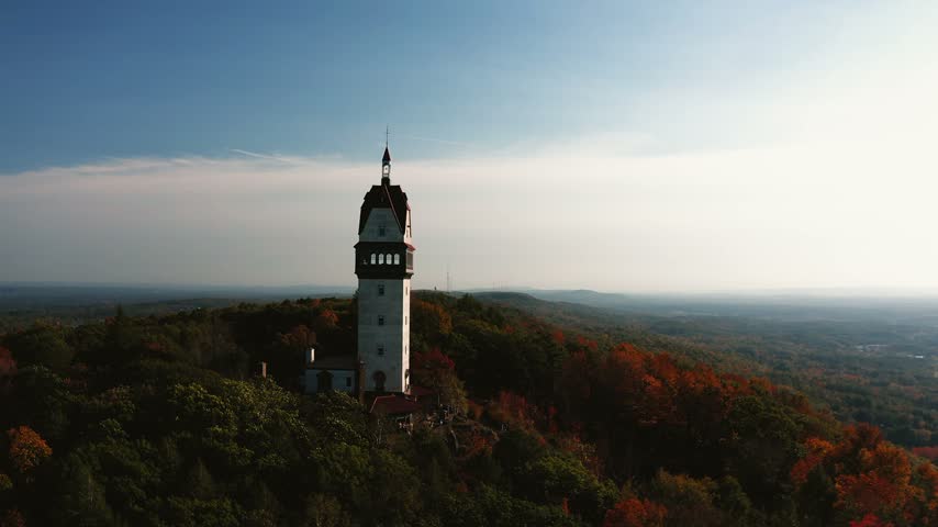 Drone shot panning across Heublein Tower in Avon Connecticut with a stunning mountain sunset backdrop
