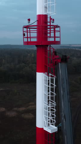 Red and white tower above forest landscape