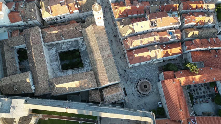 Overhead View Of The Circular Large Onofrio Fountain, Franciscan Monastery, And Pedestrians Along Stradun In Dubrovnik Old Town. - aerial shot