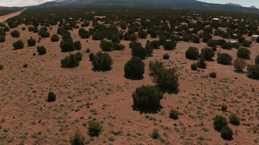 Vast open fields and desert shrubs in Flagstaff Arizona with dramatic snow-capped mountain peaks