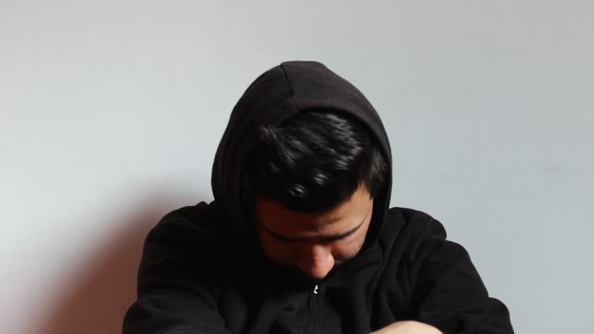 Portrait of a Hispanic man sitting with a hopeful facial expression against a white background in a photo studio. Concept of mental health, psychology and copy space
