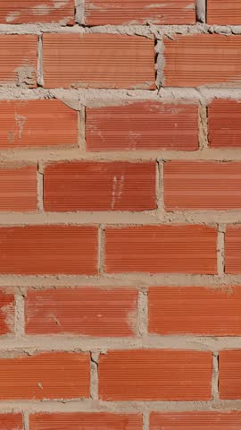 A rough textured red brick wall pattern with visible mortar lines, perfect for construction and architectural backgrounds, abstract, and design.