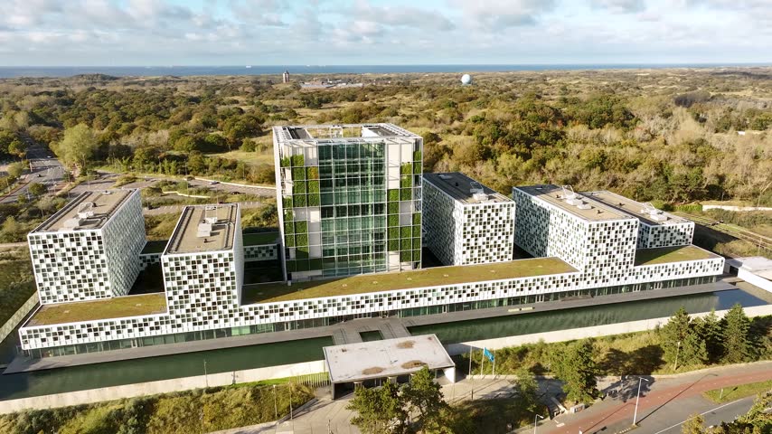 Aerial view of the International Court of Justice at the Peace Palace in The Hague, Netherlands, surrounded by lush gardens and elegant historic architecture.