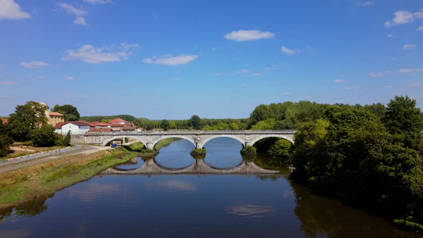 Aerial View of a countryside bridge in France over the river and surrounding greenery
