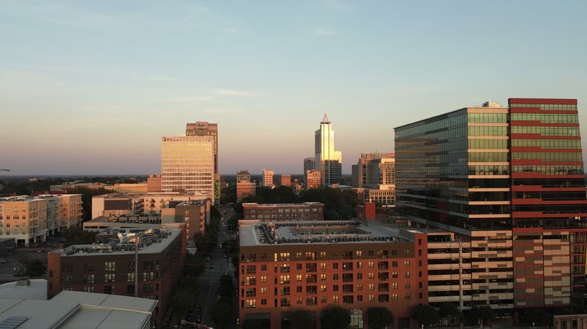 Aerial establishing shot of the downtown Raleigh, North Carolina skyline at sunset