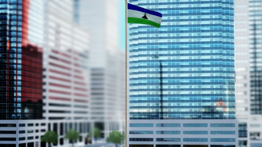Lesotho Flag Waving by Modern Glass Buildings - Daytime