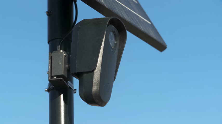 Close Up of Black License Plate Camera Against Blue Sky.