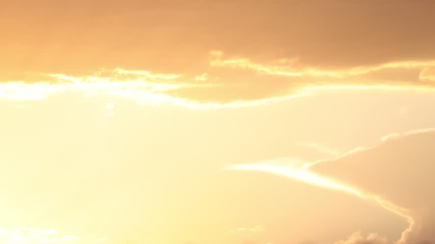 A sequence of dark clouds passes across the sky during sunset, gradually obscuring the sunlight and casting a dramatic, moody atmosphere. The changing light and cloud formations create a visually striking and dynamic scene.