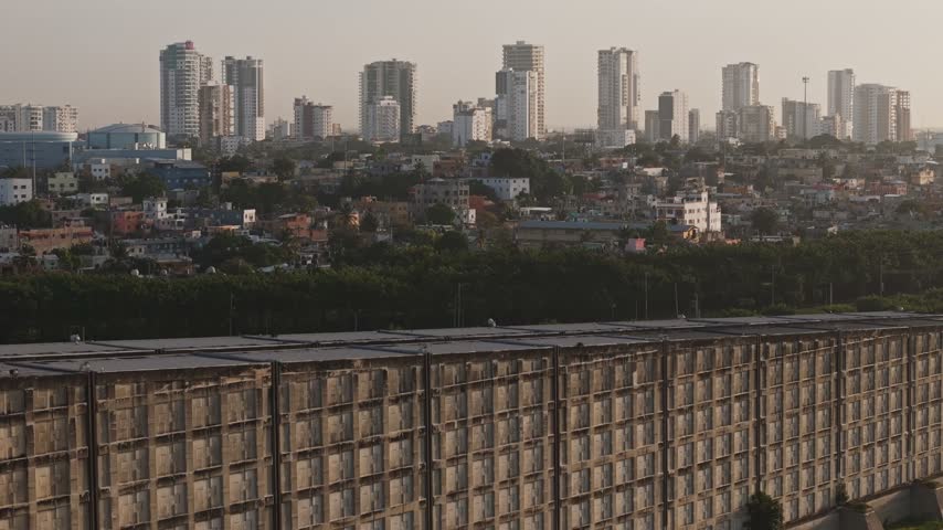 Aerial view of the Santo Domingo skyline featuring modern high-rise buildings and a large concrete structure in the foreground in Santo Domingo, Distrito Nacional, Dominican Republic.