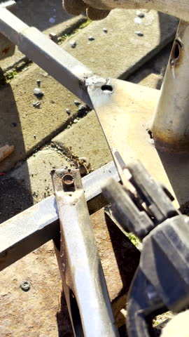 Vertical POV. Stick welding to connect pieces of metal together with blue sparks