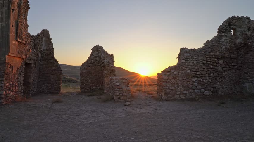 Sunset glowing through the stone ruins of an ancient archaeological site in a remote landscape