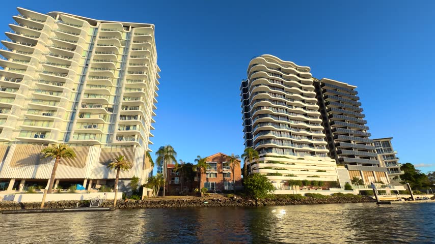 Cruising along the river past modern luxury high-rise apartments in Gold Coast, Australia.