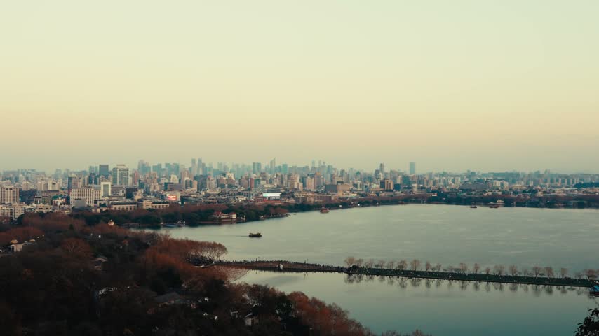 Dusk scene of major city skyline across large lake with waterfront greenery