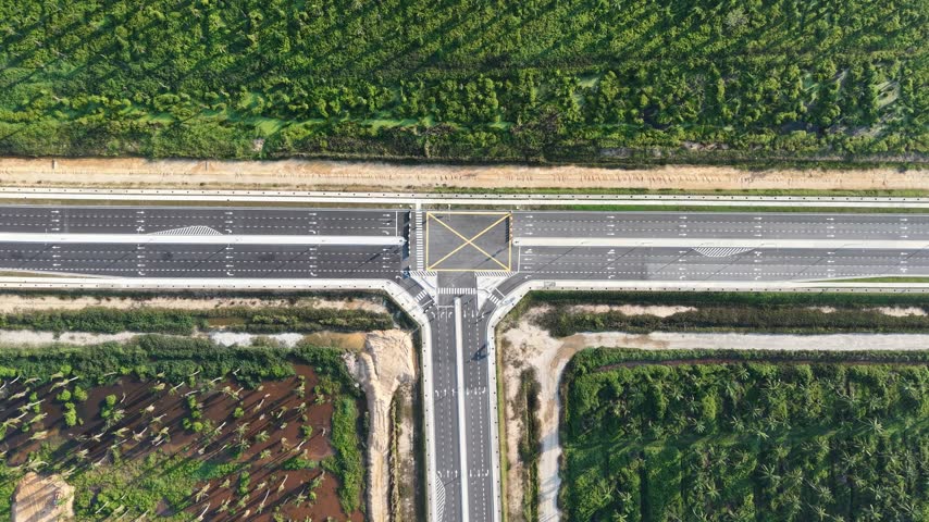 Top-down shot of a road intersection. Roads cross with clear markings