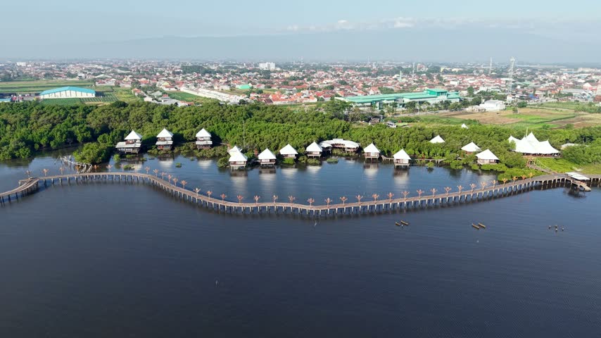 Wooden walkways connect white tented structures beside calm waters at Probolinggo