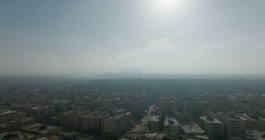 Cityscape with Pyramids Under Bright Sunlit Sky in natural light