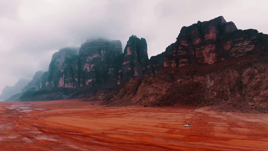Red Desert Landscape with Rocky Mountains and Overcast Sky