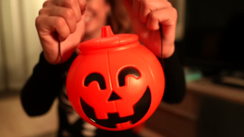 Young woman wearing a skeleton costume for a halloween party showing a spooky jack o