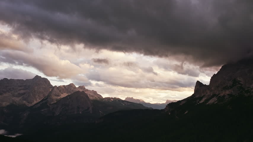 Soft Evening Light Illuminates Lake Misurina Surrounded By Dark Forests And Towering Mountain Peaks Near Misurina In The Italian Dolomites. - aerial tilt down shot