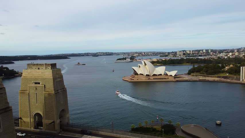 Aerial view of Sydney Harbour Bridge and Sydney Opera House with boats on the water in Sydney, New South Wales, Australia.