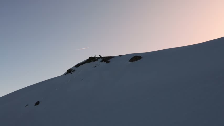 Winter Snowfield With a Narrow Trail Leading Over the Mountain Ridge and With Thin Airplane Trails